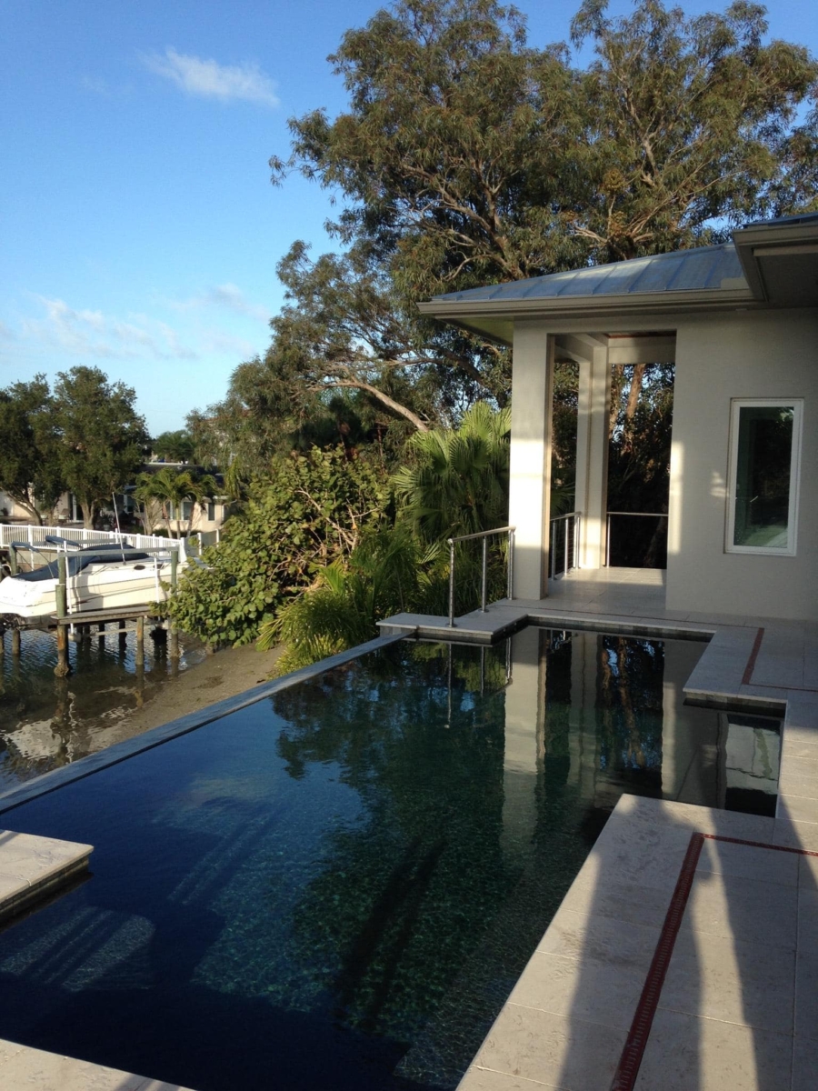 Infinity-edge pool beside a private dock on a residential canal