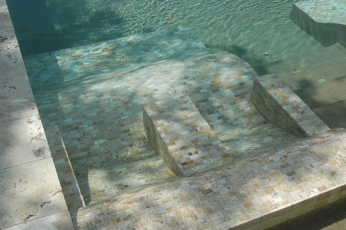 Underwater view of a pool's entry steps and tanning ledge