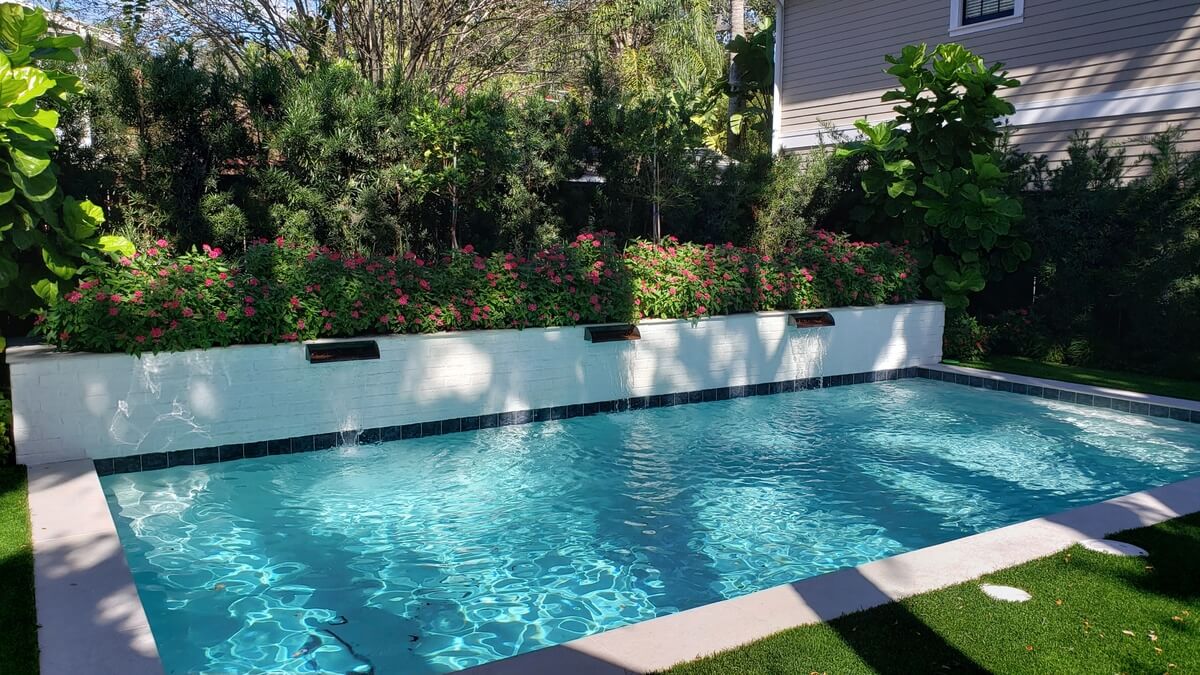 Rectangular pool with a raised wall and sheer-descent water features