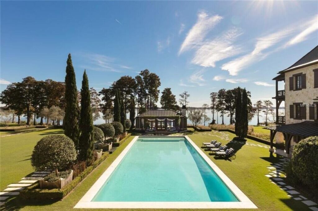 Formal rectangular pool on a lawn overlooking a lake