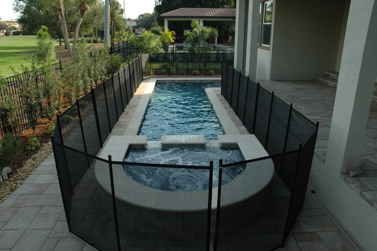 Pool and spa enclosed by a black removable safety fence